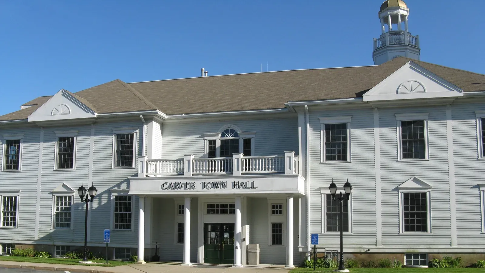 Carver Town Hall, a white clapboard building with a columned entry portico and a cupola, Carver, Massachusetts